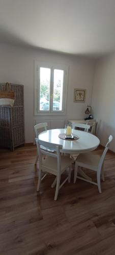 a white table and chairs in a living room at Maison Calme Lavande et coquelicots in Saint-Jean-Pla-de-Corts
