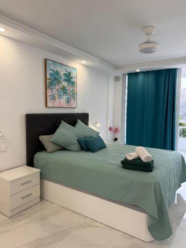 a bedroom with a green bed with a blue curtain at Ocean Glimpse- Las Americas in Costa de Adeje