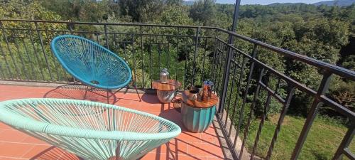 a balcony with a blue chair and a fence at Maison Calme Lavande et coquelicots in Saint-Jean-Pla-de-Corts