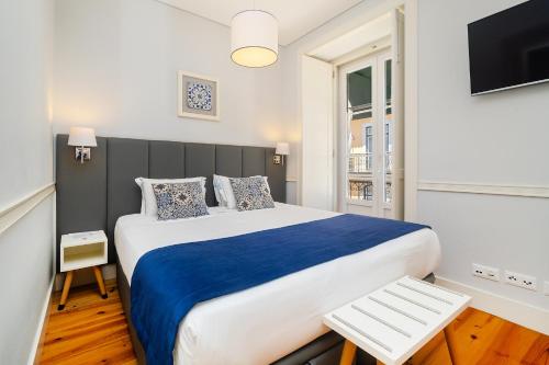 a bedroom with a large bed and a tv at Villa Baixa - Lisbon Luxury Apartments in Lisbon