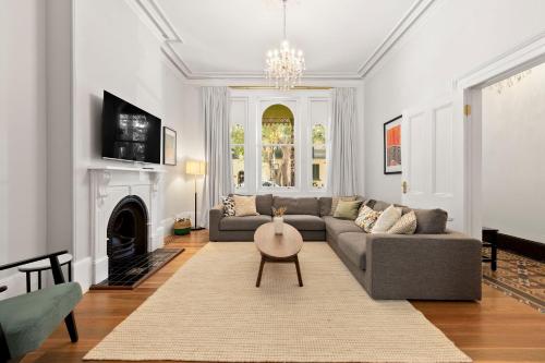 a living room with a couch and a fireplace at Elegant 6-Bed Home with Harbour Views in Sydney