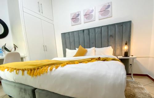 a bedroom with a large white bed with a gray headboard at Hotel Ukhay 