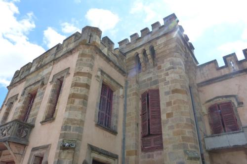 an old building with red shutters on it at Château de la Grange Fort in Issoire