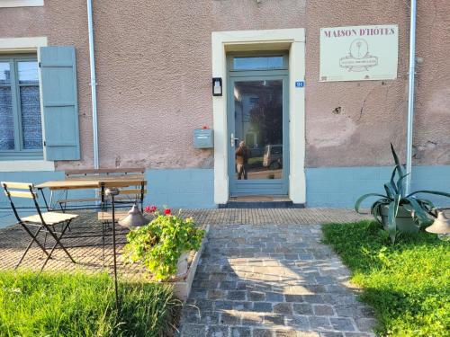 a person sitting in the door of a building at Maison d'hôtes Coeurdacier in Monthureux-sur-Saône