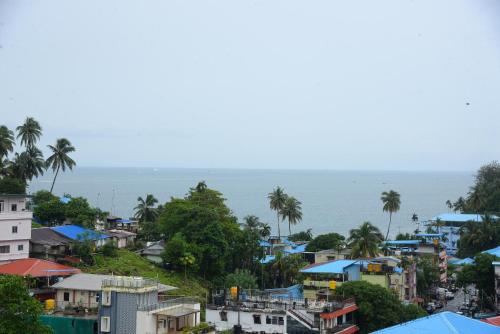 a view of a city with houses and the ocean at Deer Park Hometel in Jangli Ghāt