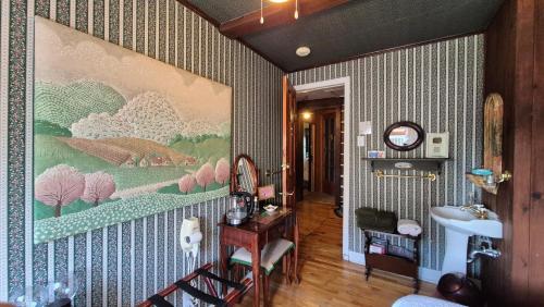 a bathroom with a large painting on the wall at Refuge du Poète in Longueuil