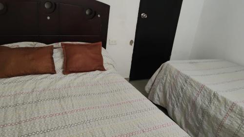 a bedroom with a bed with two pillows on it at Casa LAGOMAR in Puerto Colombia