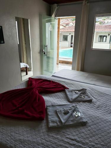 a bedroom with a bed with a red dress on it at Pousada Sinhá Moça in Diamantina