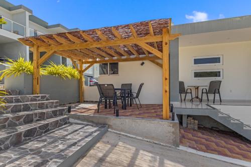 a patio with chairs and a wooden pergola at Casa paz y calidez - Papaya Hill Resort in Grote Berg