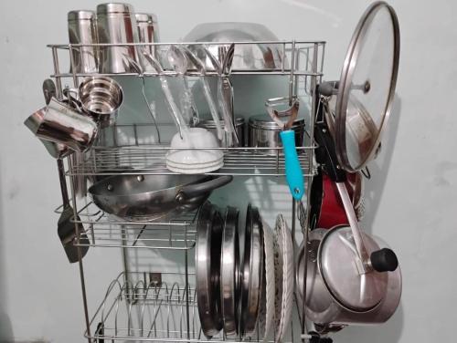 a dish drying rack with dishes and utensils at Green Homestay Kolkata - Prefer International Guest - Attach Bath - Paid Kitchen in Kolkata