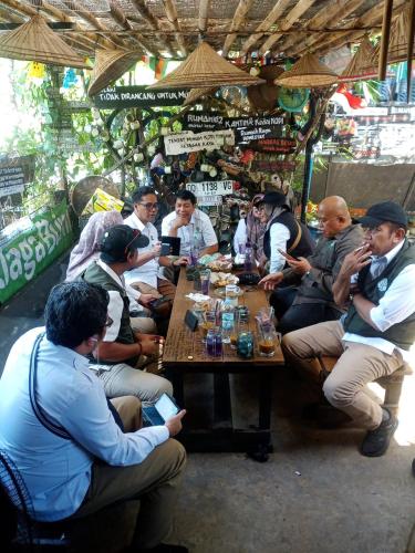 a group of people sitting around a wooden table at Rammang Rammang Guest House in Kasijala