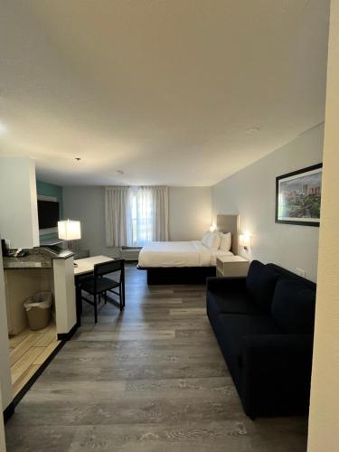 a hotel room with a bed and a couch at MainStay Suites Sterling near Dulles Town Center in Sterling
