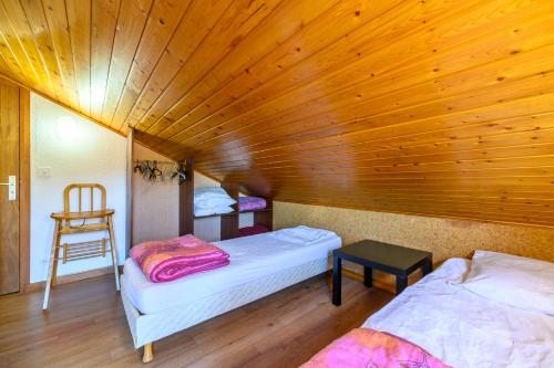 a room with two beds and a wooden ceiling at Les Chalets Du Pres D'amont in Vagney