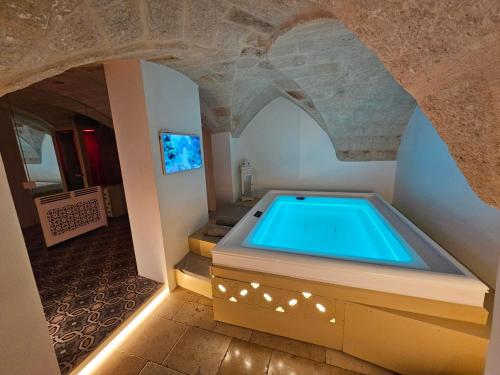 a hot tub in a room with a stone wall at Christian's Suites & Spa in Fasano