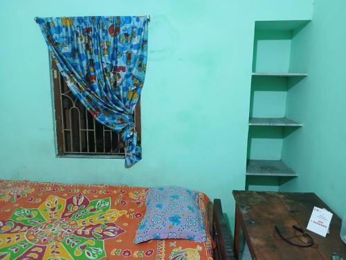 a room with a window with a bed and a table at Green Homestay Kolkata - Prefer International Guest - Attach Bath - Paid Kitchen in Kolkata