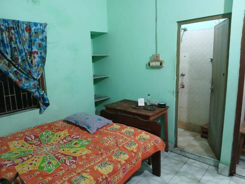 a bedroom with a bed and a table and a mirror at Green Homestay Kolkata - Prefer International Guest - Attach Bath - Paid Kitchen in Kolkata