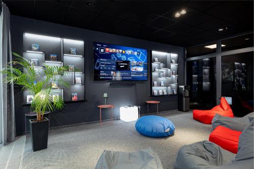 a room with a flat screen tv on a wall at Luna Self Check-in Hotel Klaipeda in Klaipėda