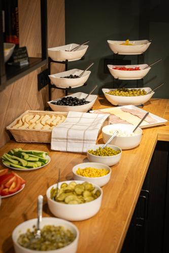 a buffet with bowls of food on a table at Luna Self Check-in Hotel Klaipeda in Klaipėda