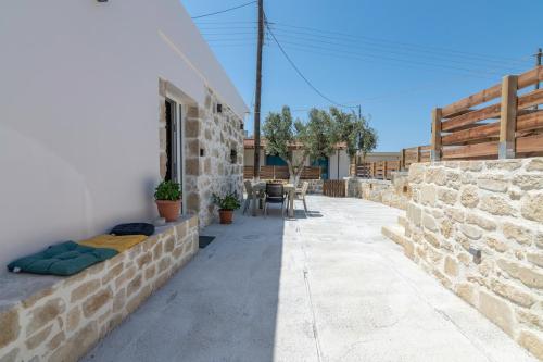 a patio of a house with a stone wall at Anamniseis Giorgio Falasarna in Plátanos