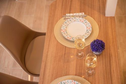 a table with two plates and two glasses of wine at Anamniseis Giorgio Falasarna in Plátanos