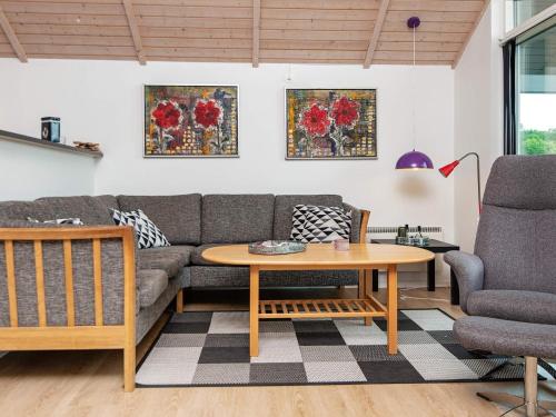 a living room with a couch and a table at Bright Family Cottage by Kelstrup Beach in Kelstrup Strand