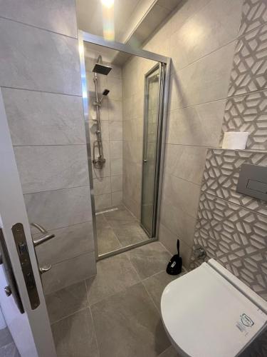 a bathroom with a shower and a white toilet at Kadıköy Miski Amber in Istanbul