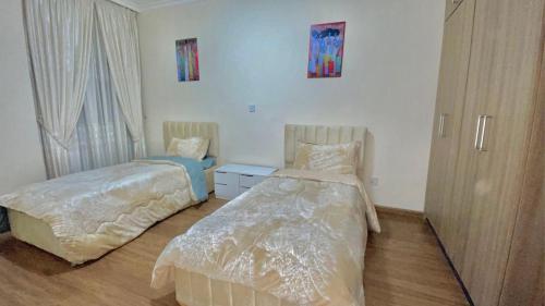 Un dormitorio con dos camas y una ventana. en Mimo Apartment, en Addis Ababa