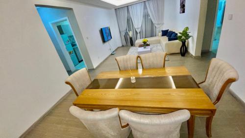 Un comedor con mesa y sillas de madera. en Mimo Apartment, en Addis Ababa