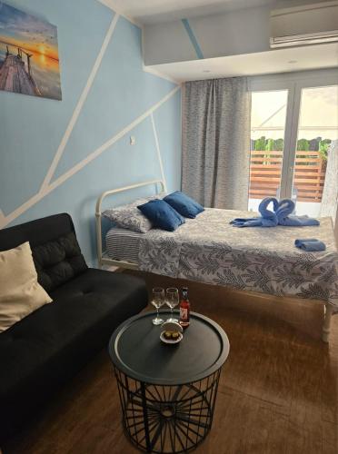 a room with a bed and a couch and a table at Studio in the heart of Paphos in Paphos