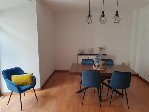 a dining room with a table and blue chairs at O AL da Baixa in Figueira da Foz
