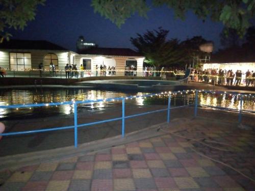 Nazrethkereyu hill resort hotel的一群人晚上站在游泳池周围