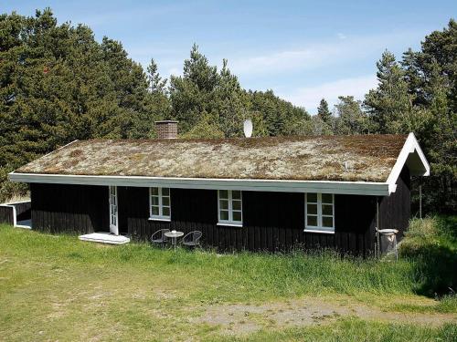an old black house with grass on the roof at 6 person holiday home in Ålbæk-By Traum in Skram