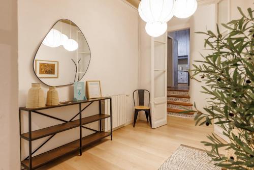 a room with a mirror and a table with a chair at Bravissimo Plaça del Vi, Authentic Historic Apartment in Girona