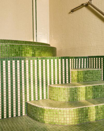 a bathroom with green tiled stairs in a room at Le Château de la Tour in Gouvieux