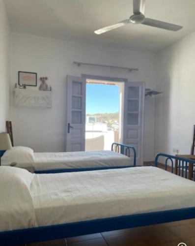 a bedroom with two beds and a ceiling fan at Villa Iza in Skala