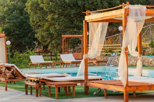 a group of tables and chairs next to a pool at MonteSoprano Agriturismo - Resort - Spa - Gym -Camping - Suite in Capizzi