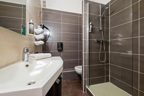 a bathroom with a sink and a shower at Hotel Saint Paul in Noirmoutier-en-l'lle