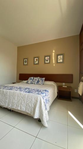 a bedroom with a bed with a blue and white comforter at Mara Palace Hotel in Vassouras