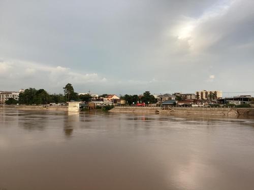 a view of a river with houses and buildings at Naris Riverside in Ban Wat Tha Maprang