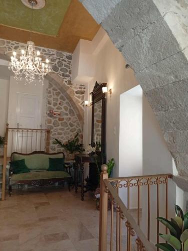 a living room with a staircase and a chandelier at ARCHONTIKO HOTEL Kalymnos in Kalymnos