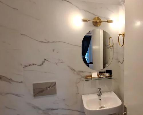 a white bathroom with a sink and a mirror at ARCHONTIKO HOTEL Kalymnos in Kalymnos