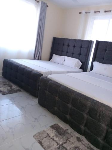 two beds sitting next to each other in a bedroom at Cozy Homes 2 in Mombasa
