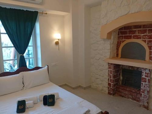 a bedroom with a bed with a brick fireplace at ARCHONTIKO HOTEL Kalymnos in Kalymnos