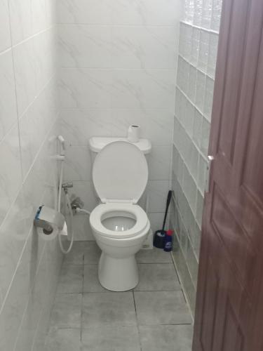 a bathroom with a white toilet in a stall at Cozy Homes 2 in Mombasa