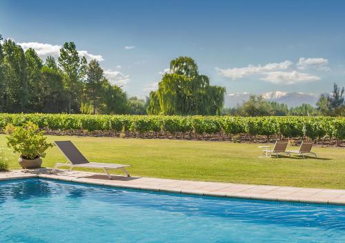 two lounge chairs sitting next to a swimming pool at Postales by DOT Boutique in Colonia Las Rosas