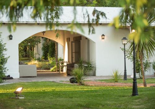 a white house with an archway in a yard at Postales by DOT Boutique in Colonia Las Rosas