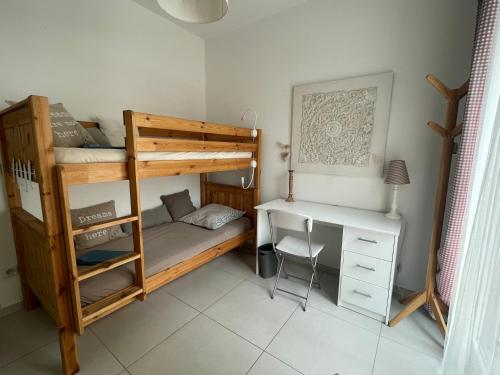 a bedroom with two bunk beds and a desk at La Maison Blanche in Arles