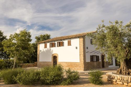 a white house with a tree in front of it at Mas d'en Jan in Roquetas