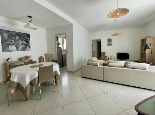a living room with a table and a couch at La Maison Blanche in Arles