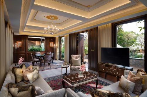 a living room with a couch and a television at The Leela Palace Udaipur in Udaipur
